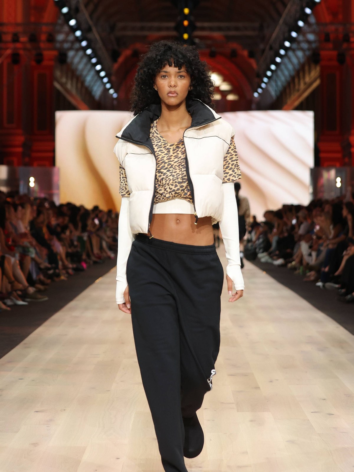 Runway model in a white jacket and black trousers at the P.E Nation showcase