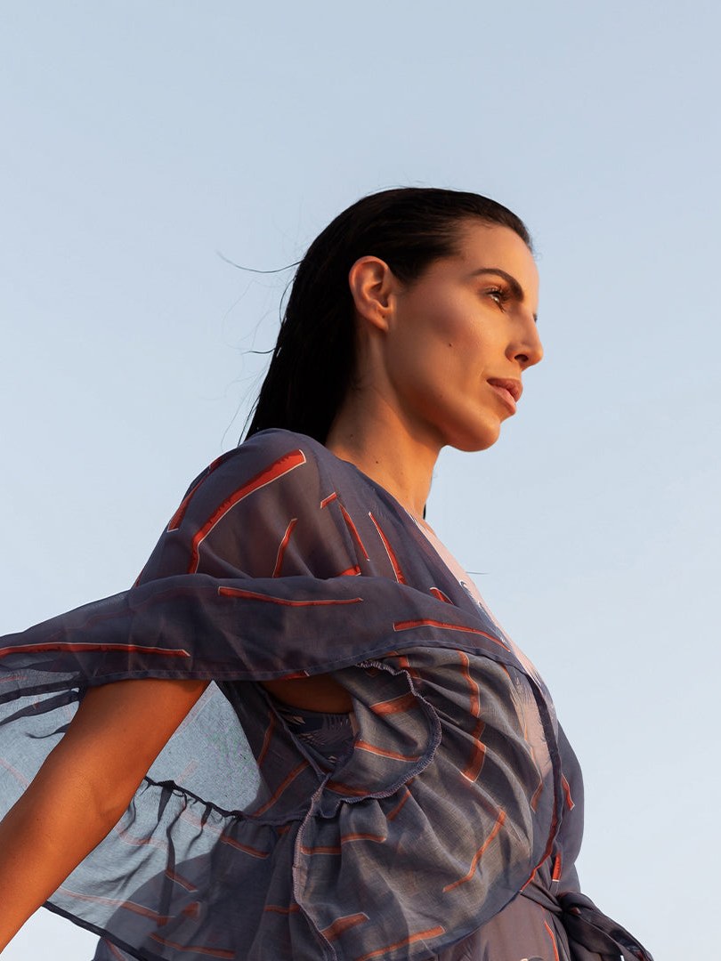 Model in an Ancora printed wrap against a pale sky