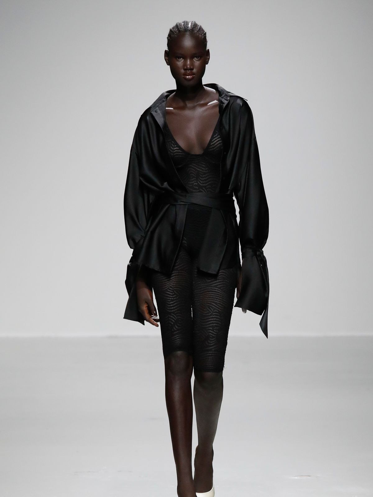Model in a black sheer Atlein wrap top and shorts