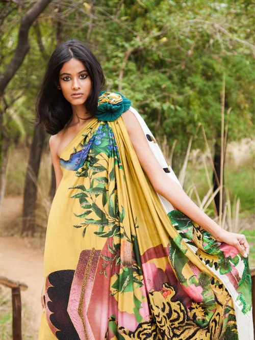 Model in a yellow and green patterned draped dress outdoors