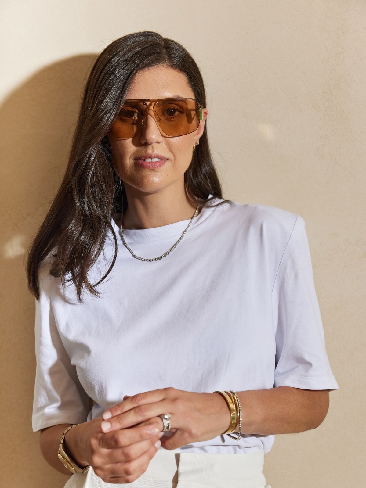 Jess Pec in brown sunglasses and a white tee