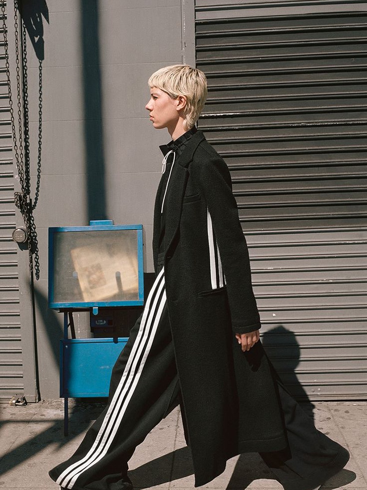 Y-3 runway model in a long black coat with white three stripes