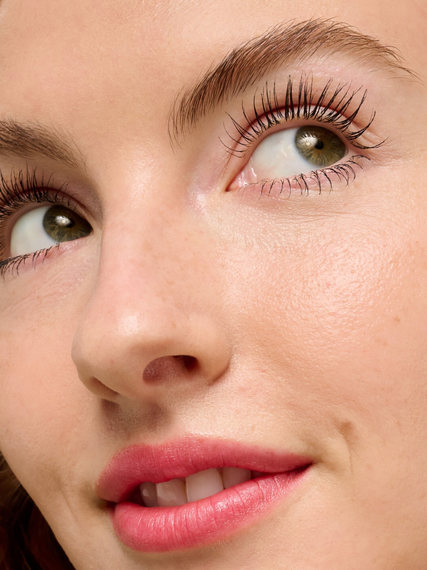 Close up of a woman with curled lashes and a pink lip