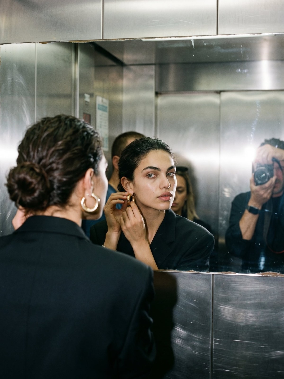 Women getting ready together in a mirrored elevator
