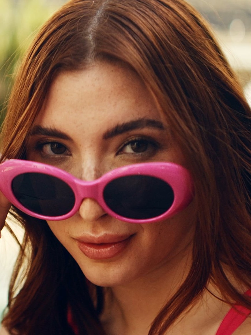 Close portrait of a woman in pink swimwear and sunglasses