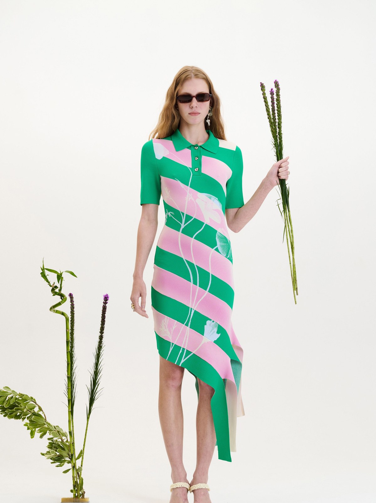 Model in a green and pink striped PH5 dress holding a stem