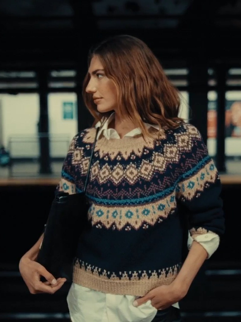 Model wearing a patterned knit on a New York subway platform