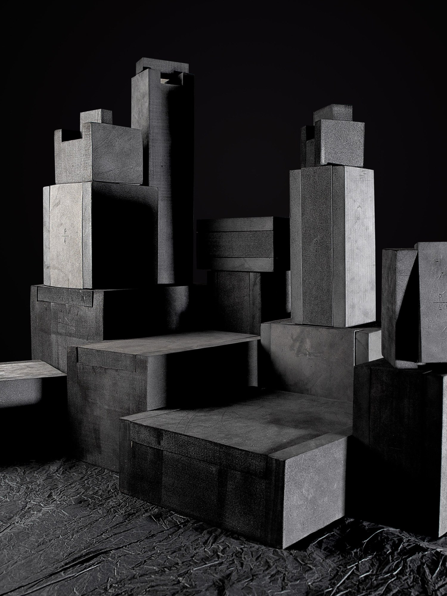 Grey stone blocks arranged as a still life in a dark room