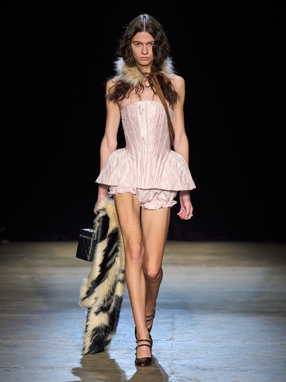 Model in a pale pink sculptural mini dress on the AKNVAS Fall 2026 runway