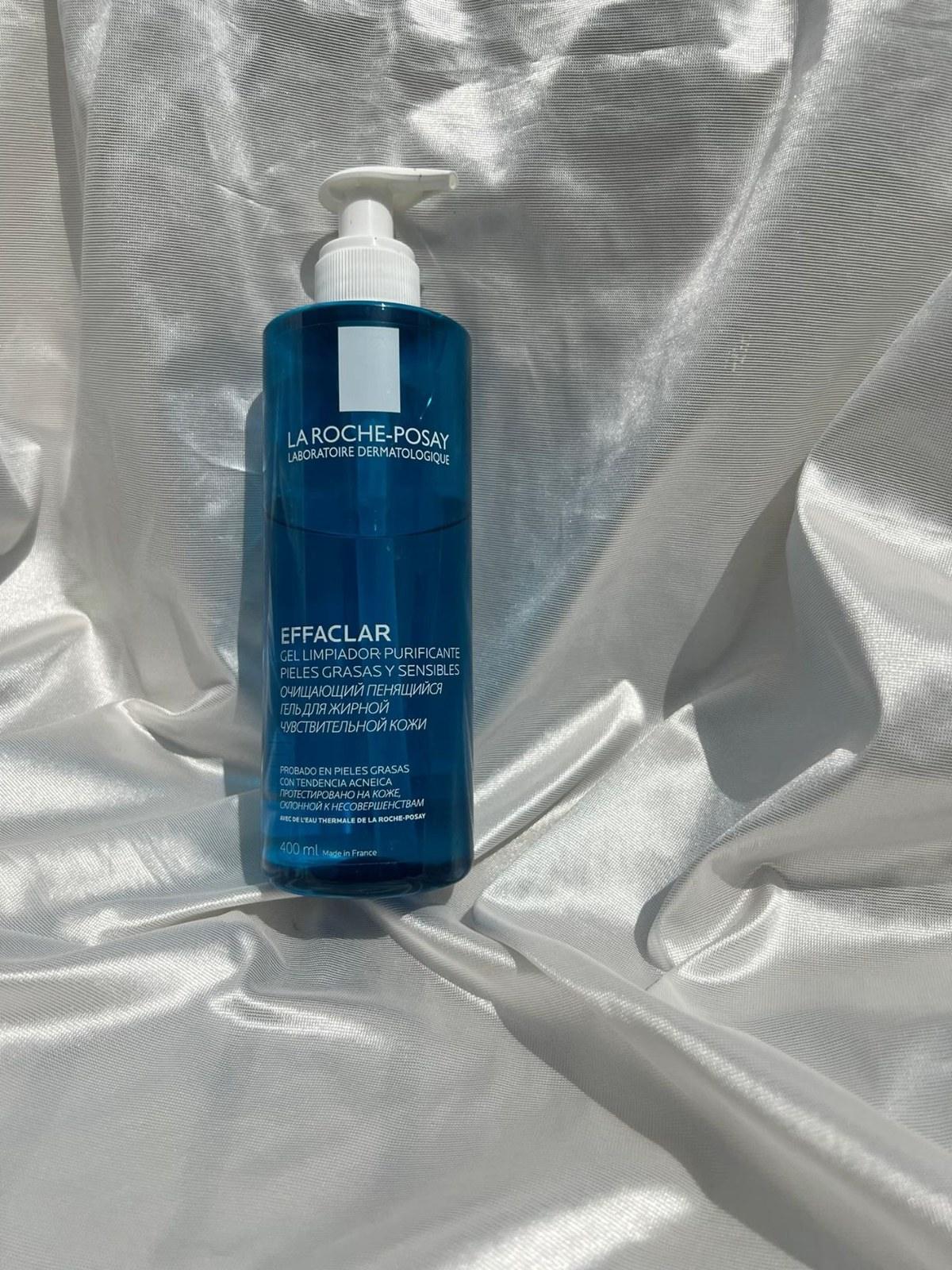 Bottle of La Roche-Posay Effaclar gel cleanser lying on a silver satin sheet