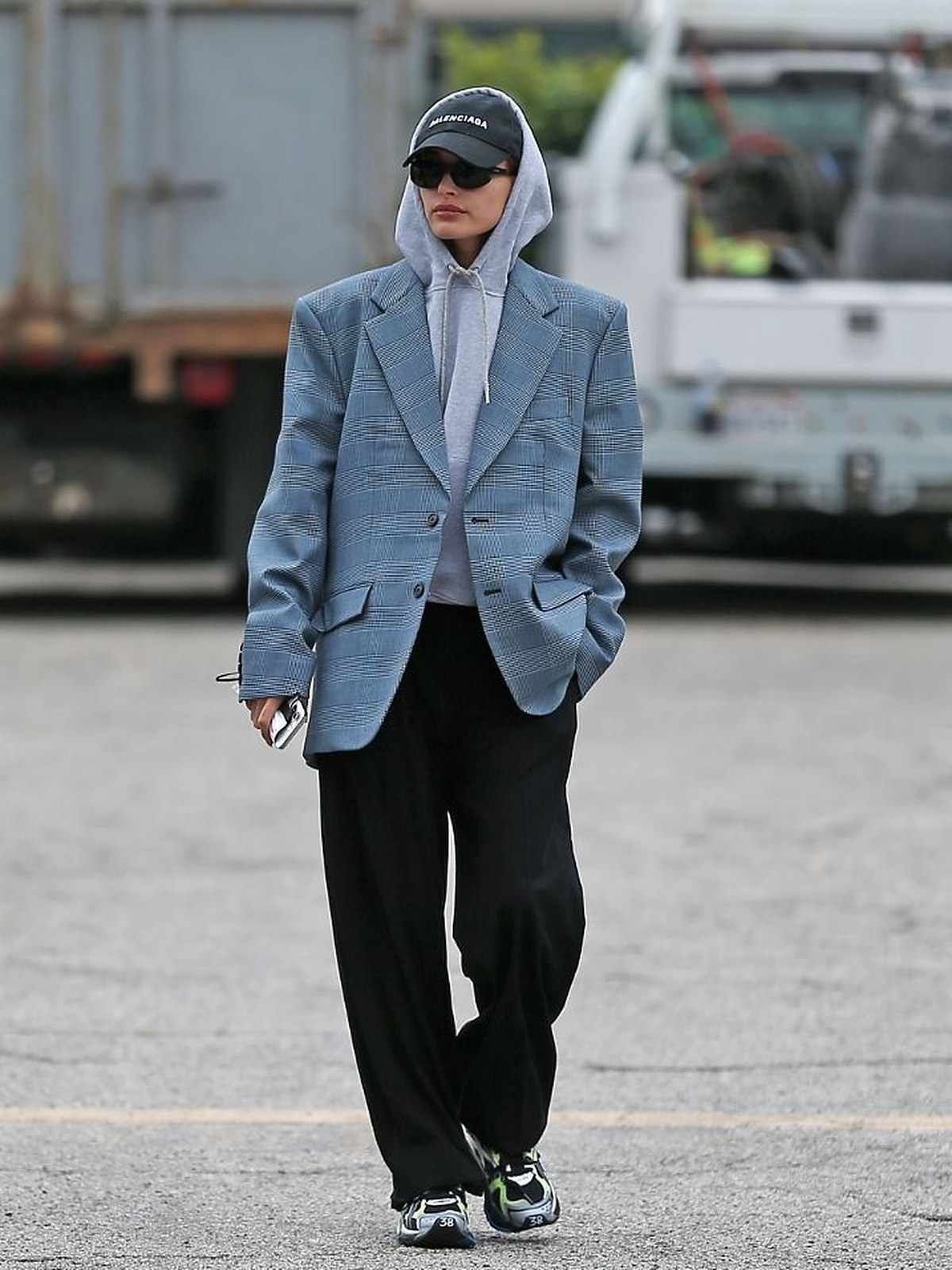 Person in a grey blazer and black trousers on a city street