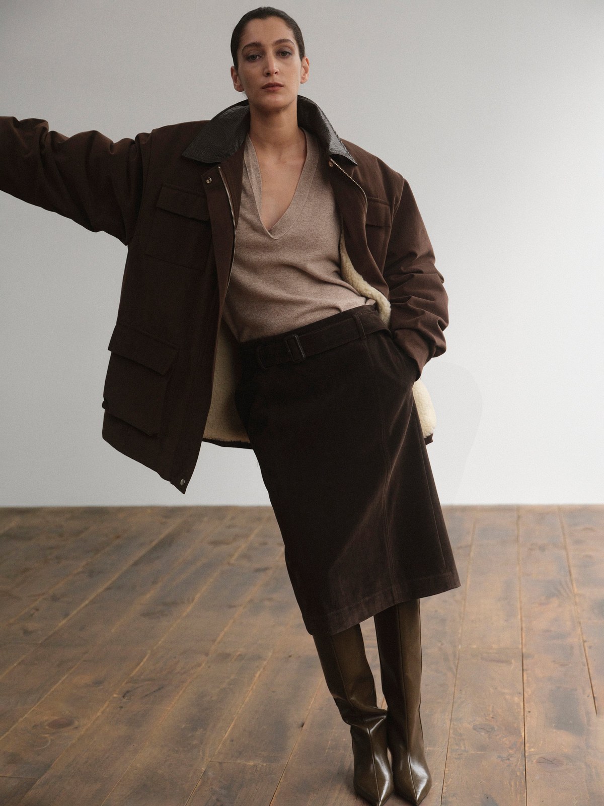 Model wearing a relaxed brown jacket and tonal skirt in a studio