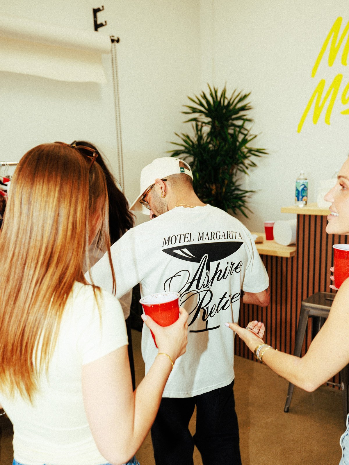 Friends wearing Motel Margarita tees at a lively indoor party