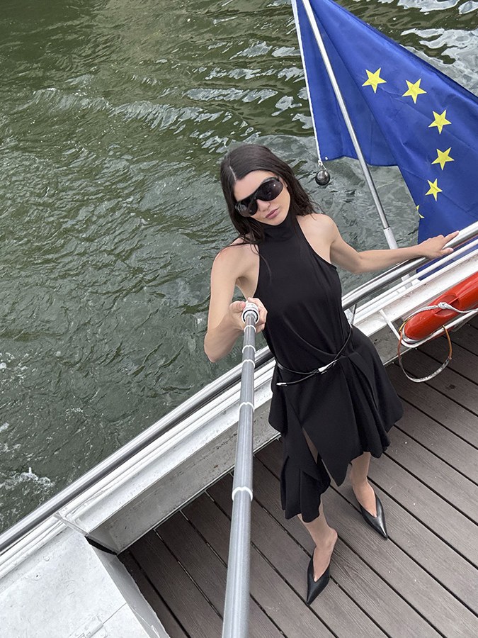 Model in a black dress on a boat by the Seine