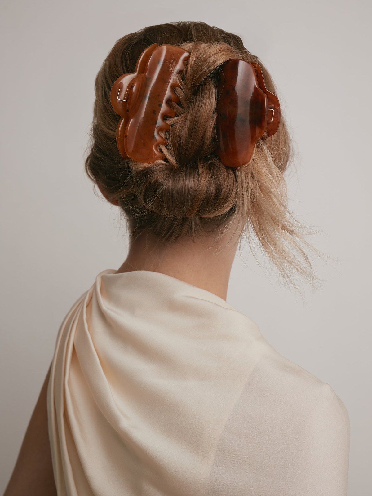 Model with a glossy tortoiseshell claw clip in a low updo