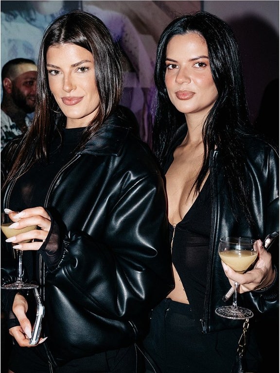 Two guests in black leather looks at the BY.DYLN opening night