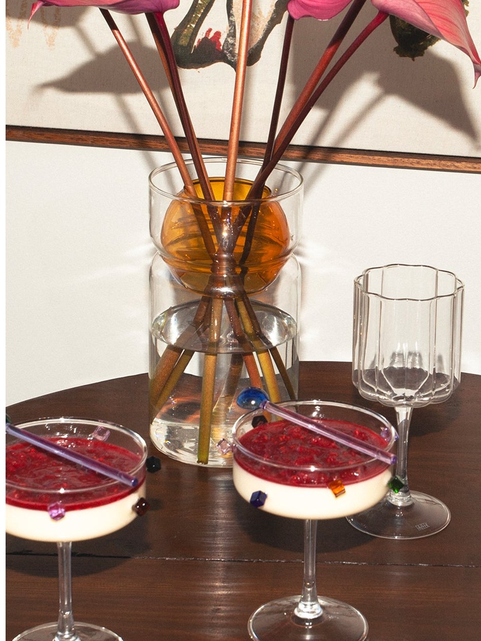 Flower stems and coupe glasses arranged on a dining table