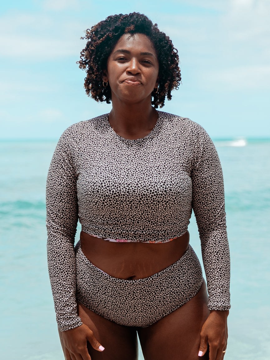 A model in a gray patterned swim set on the beach