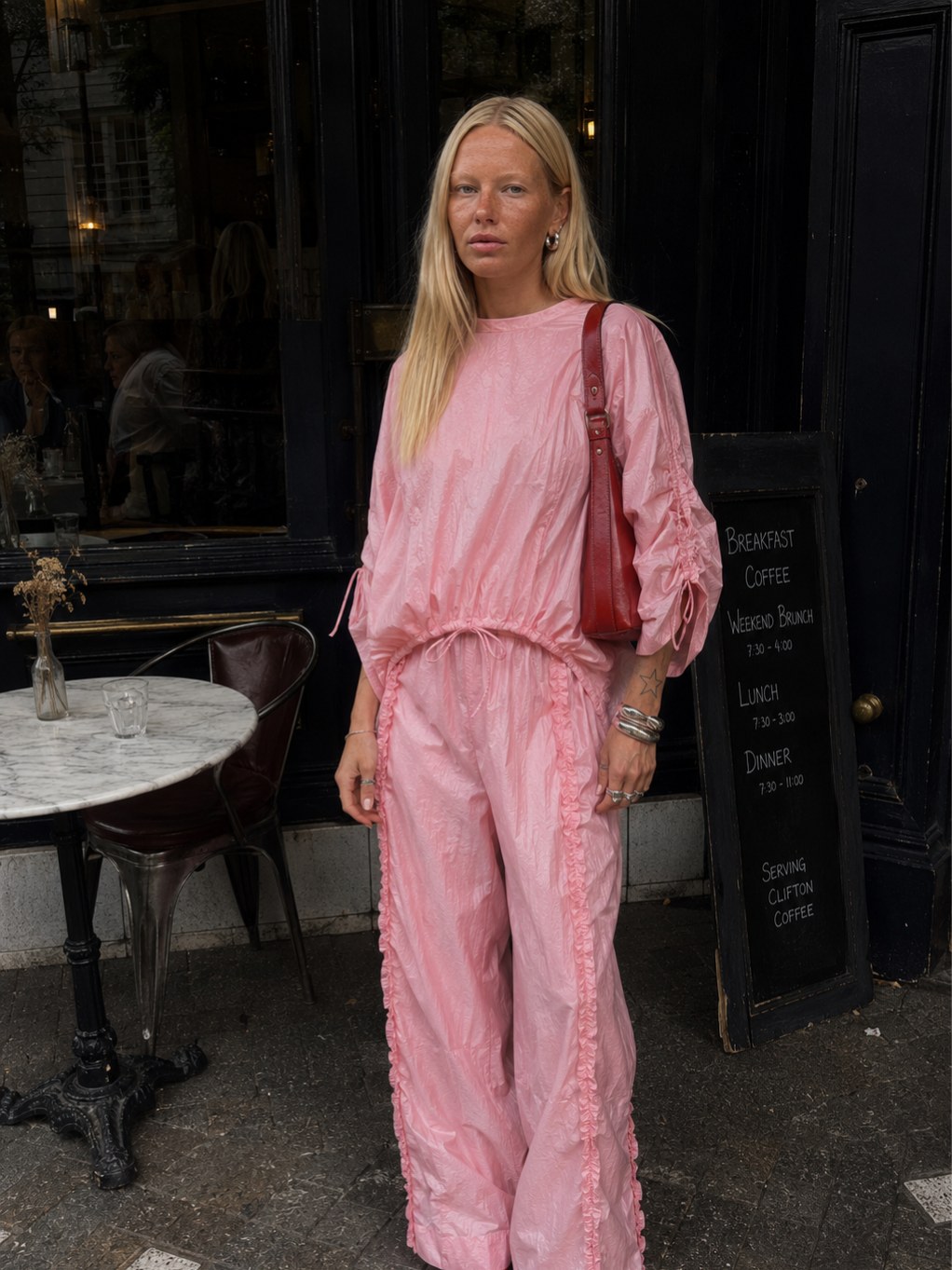 Woman in a pink matching outfit outside a cafe