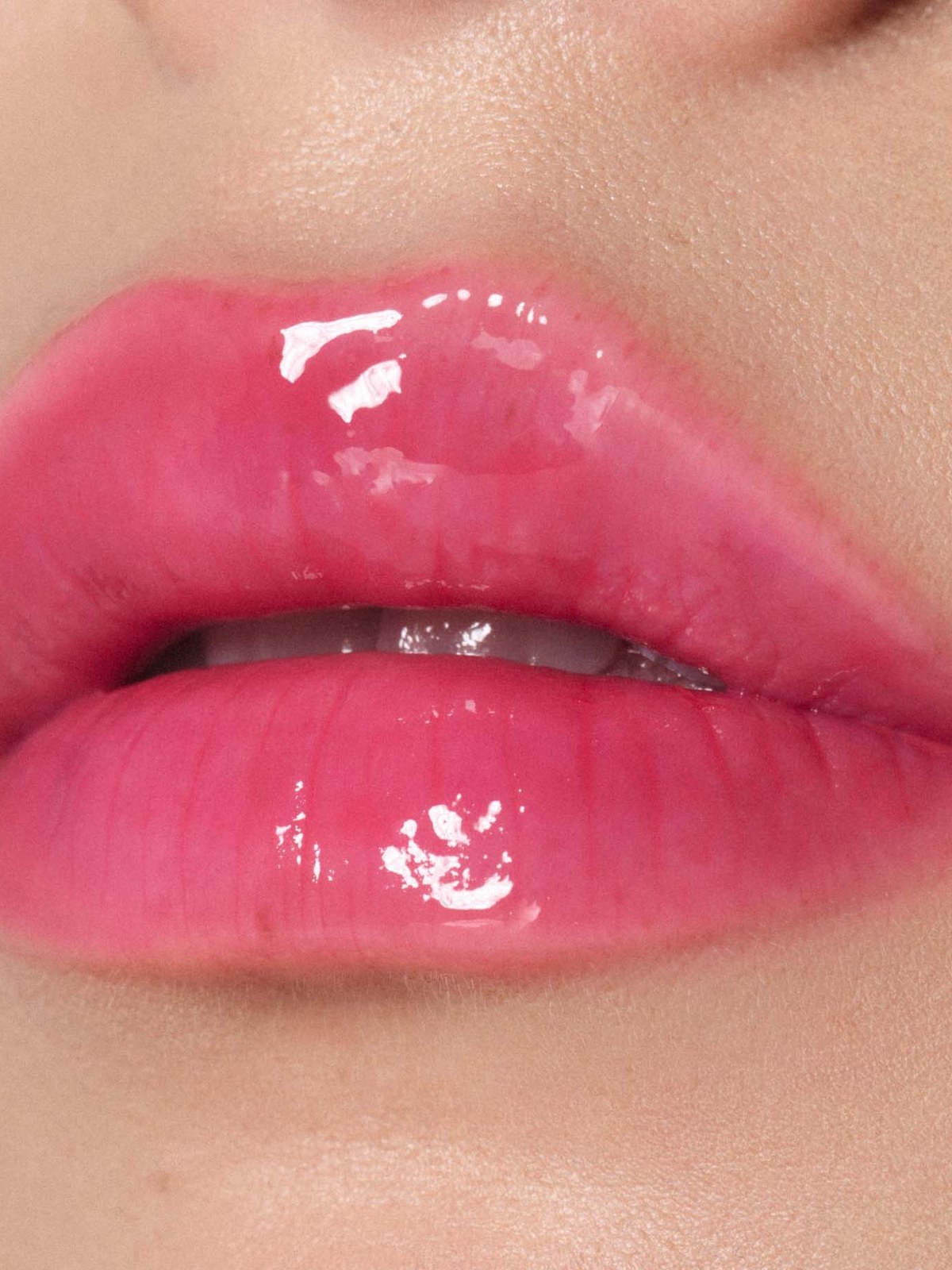 Close-up of glossy hot pink lips