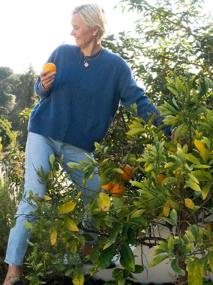 Dr. Barbara Sturm in a blue sweater in a garden