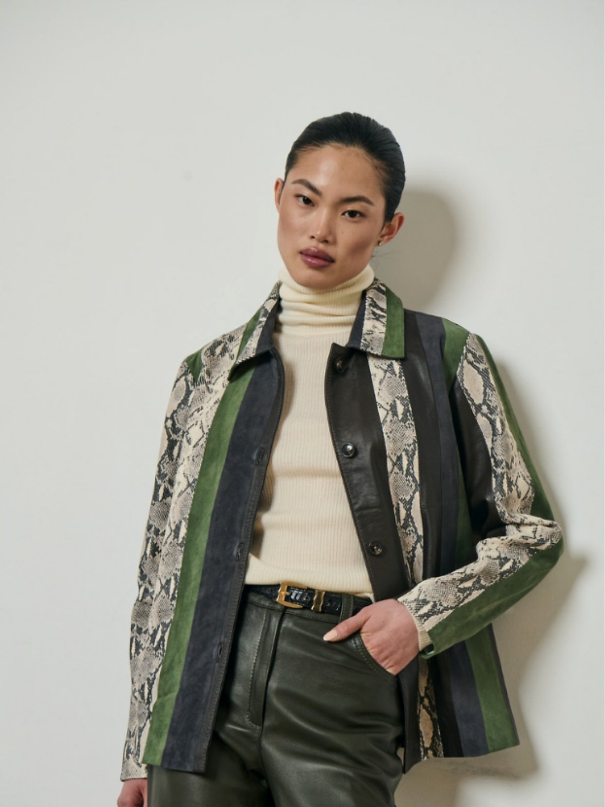 Model in a green and black striped coat with snake-pattern panels