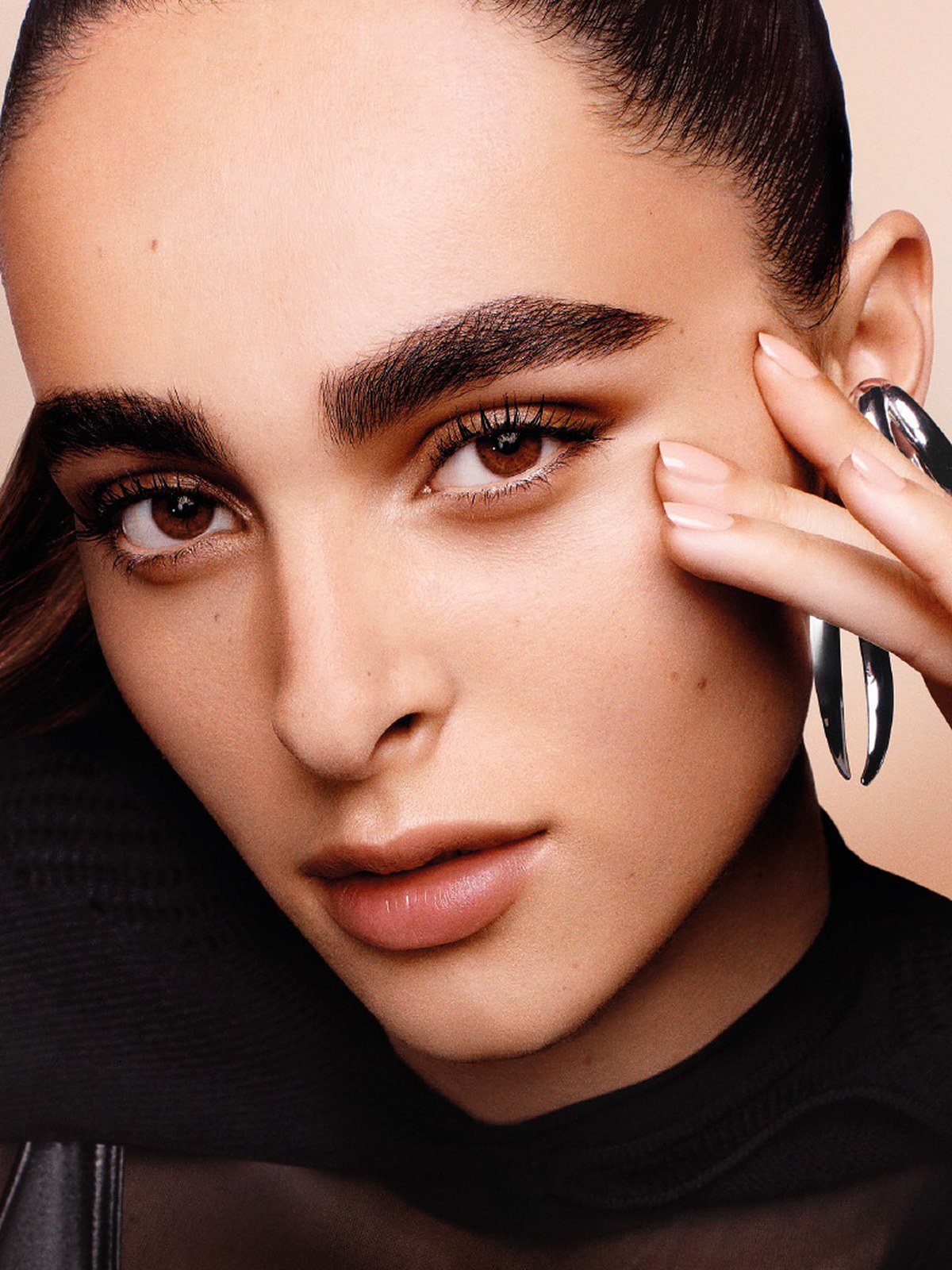 Close beauty portrait of a model with dark brows, natural skin and a nude lip