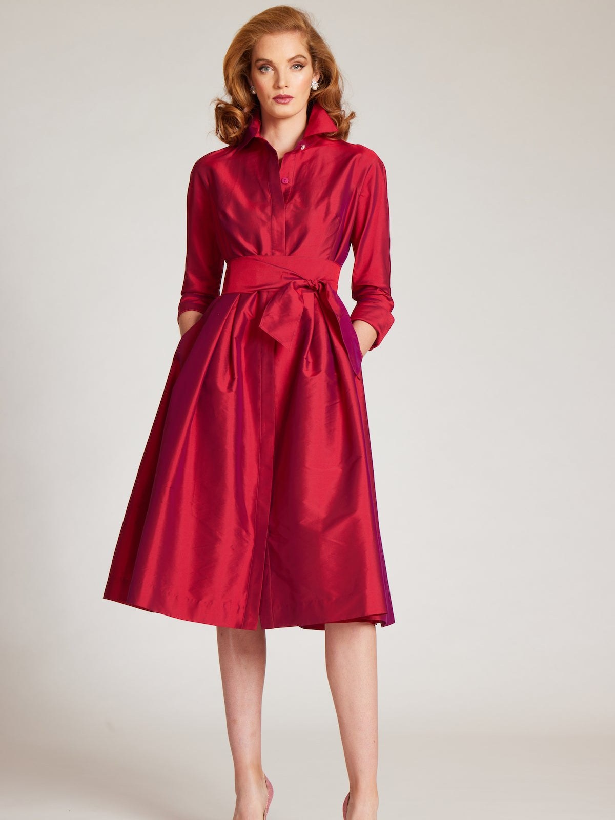 Model in a red taffeta shirtdress with a tie waist