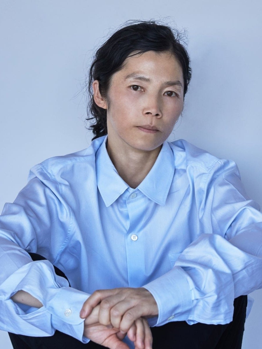 Artist KOO JEONG A seated in a pale blue shirt for the NONFICTION Biennale project