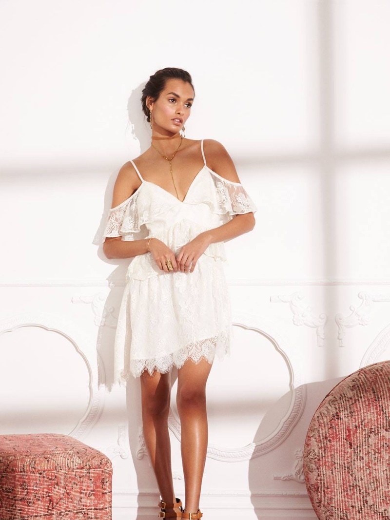 Model in an ivory Tularosa off-shoulder dress in a bright studio lookbook