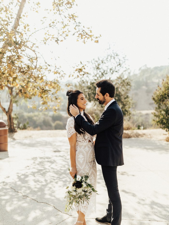 Bride in a Stone Cold Fox lace two-piece with her groom at an outdoor wedding