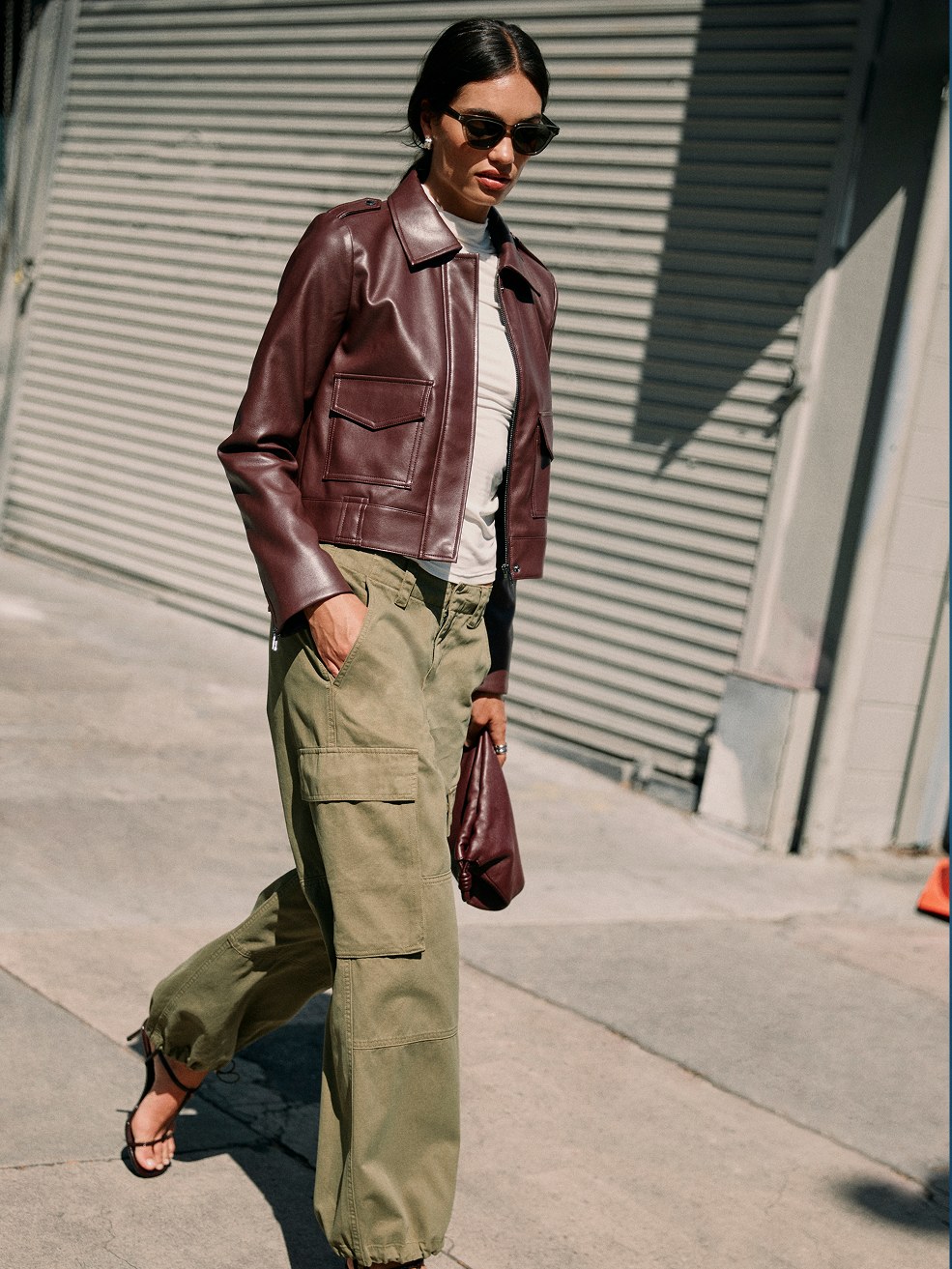Model in a brown jacket and olive utility pants on a Los Angeles sidewalk