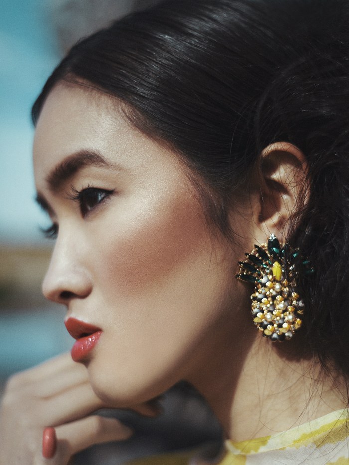 Close profile of a model wearing a jeweled statement earring