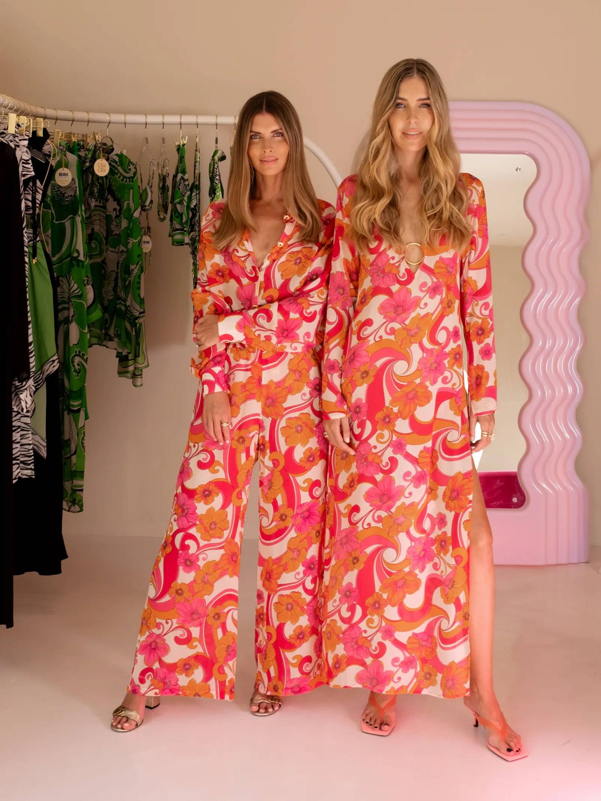 Two women in coordinated vivid print outfits in a Cin Cin studio