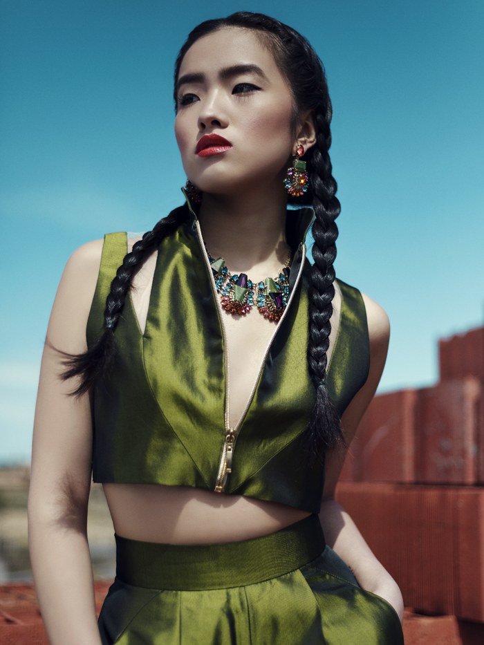 Model in a green satin outfit with multicolor crystal jewelry outdoors