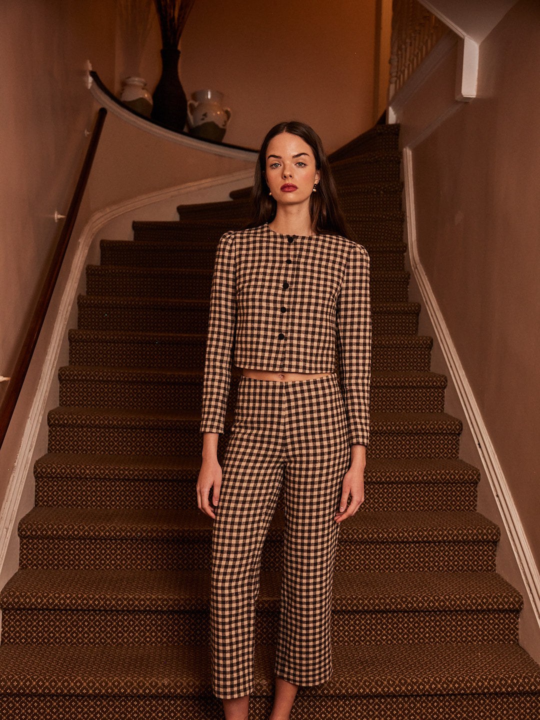 Model in a black and white check set on a patterned staircase