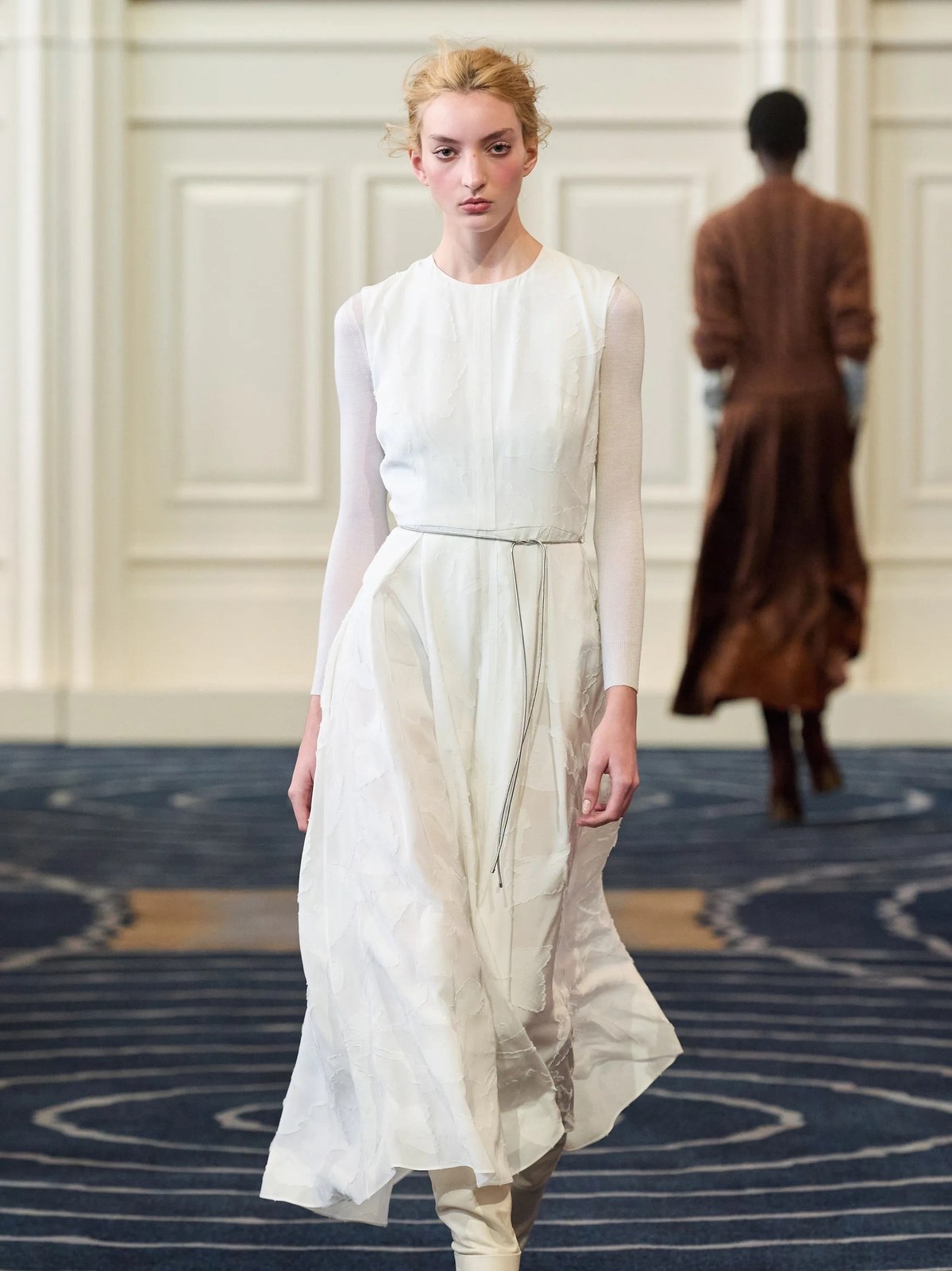 Model in a white draped dress on the Alejandra Alonso Rojas runway