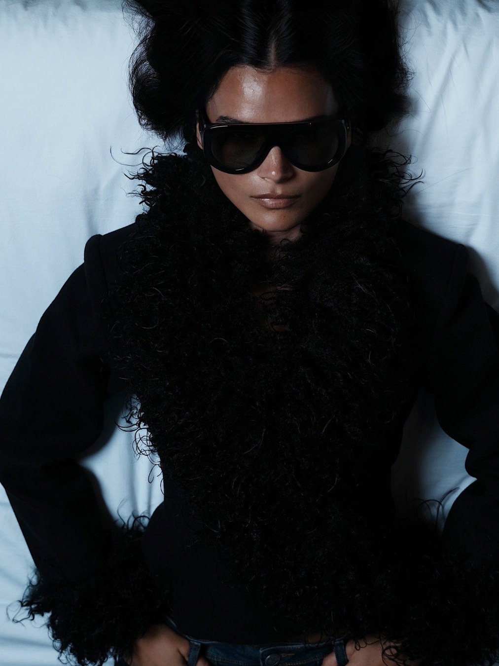 Model wearing a black fur-trimmed jacket and sunglasses