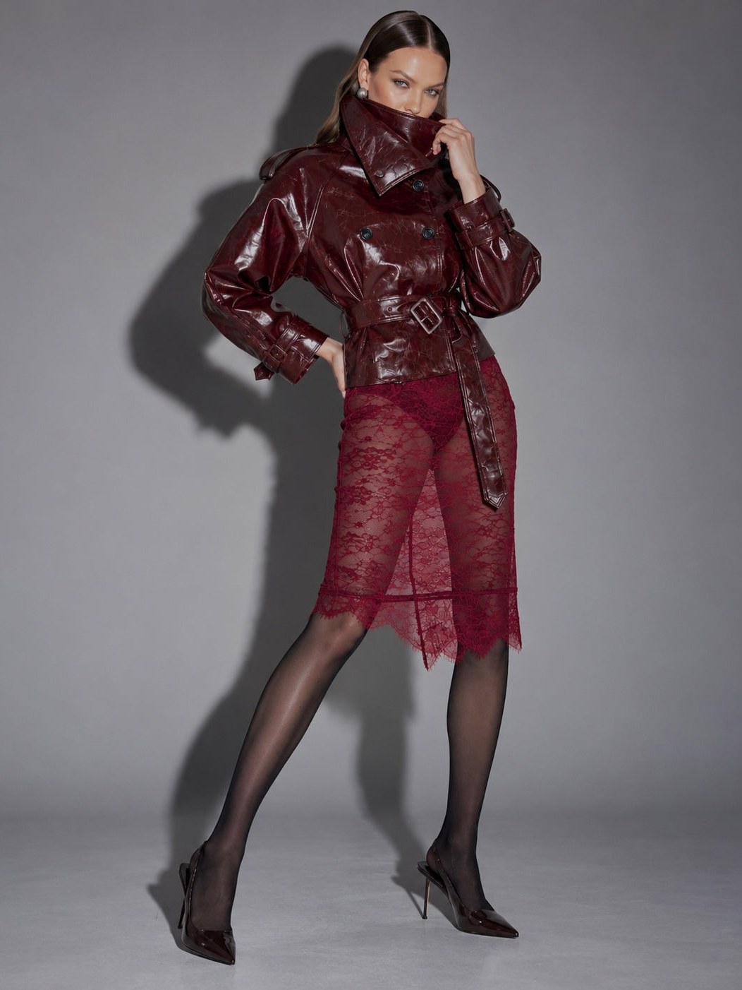 Model in a burgundy look against a gray studio background