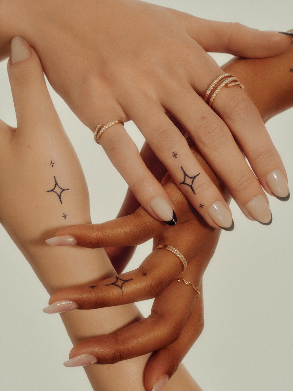 Hands layered with tiny temporary tattoo designs
