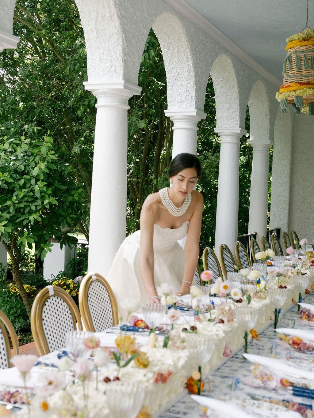 Stephanie Nass sets a long outdoor wedding table beneath white arches