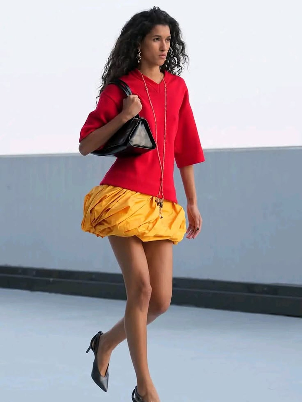 Moschino runway model in a red top and yellow skirt