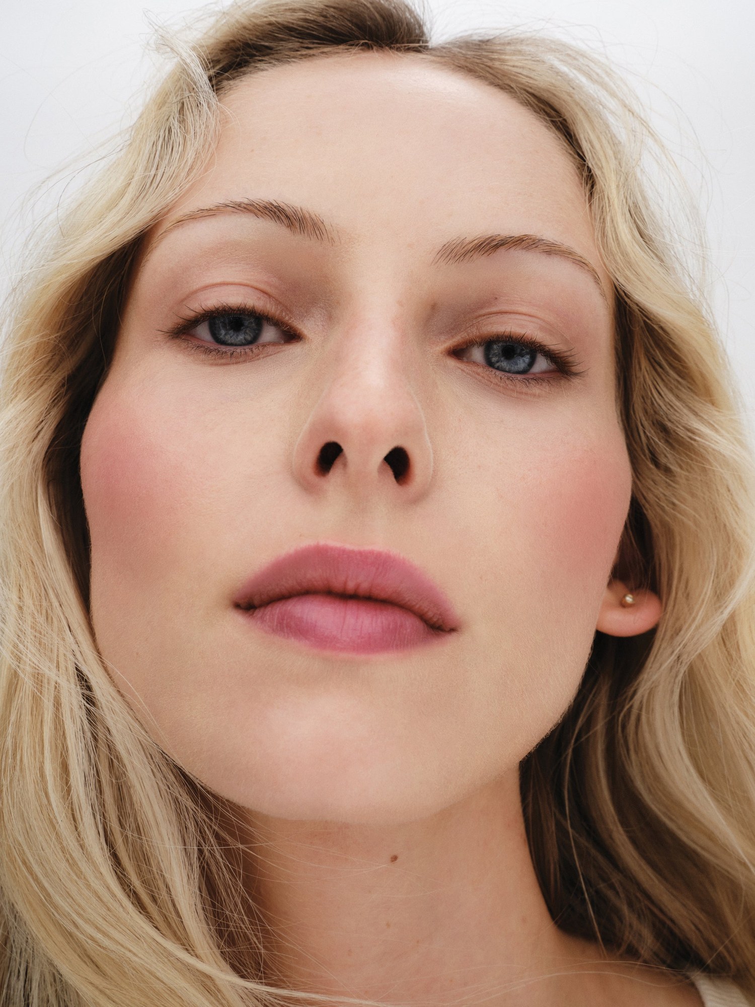 Close portrait of a blonde model with pink flush on her cheeks