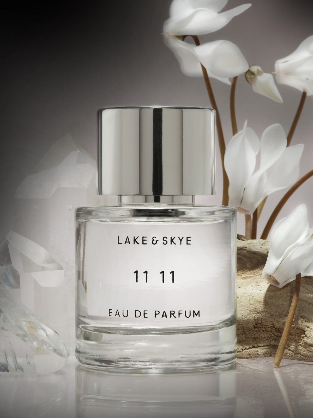Lake & Skye 11 11 bottle staged with white flowers and pale natural textures