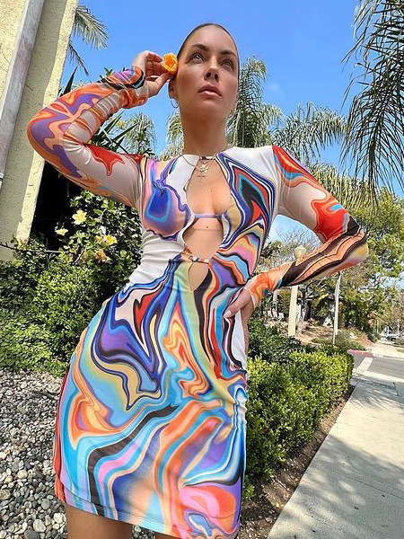 Community model wearing a colorful AFRM print dress on a sunny street