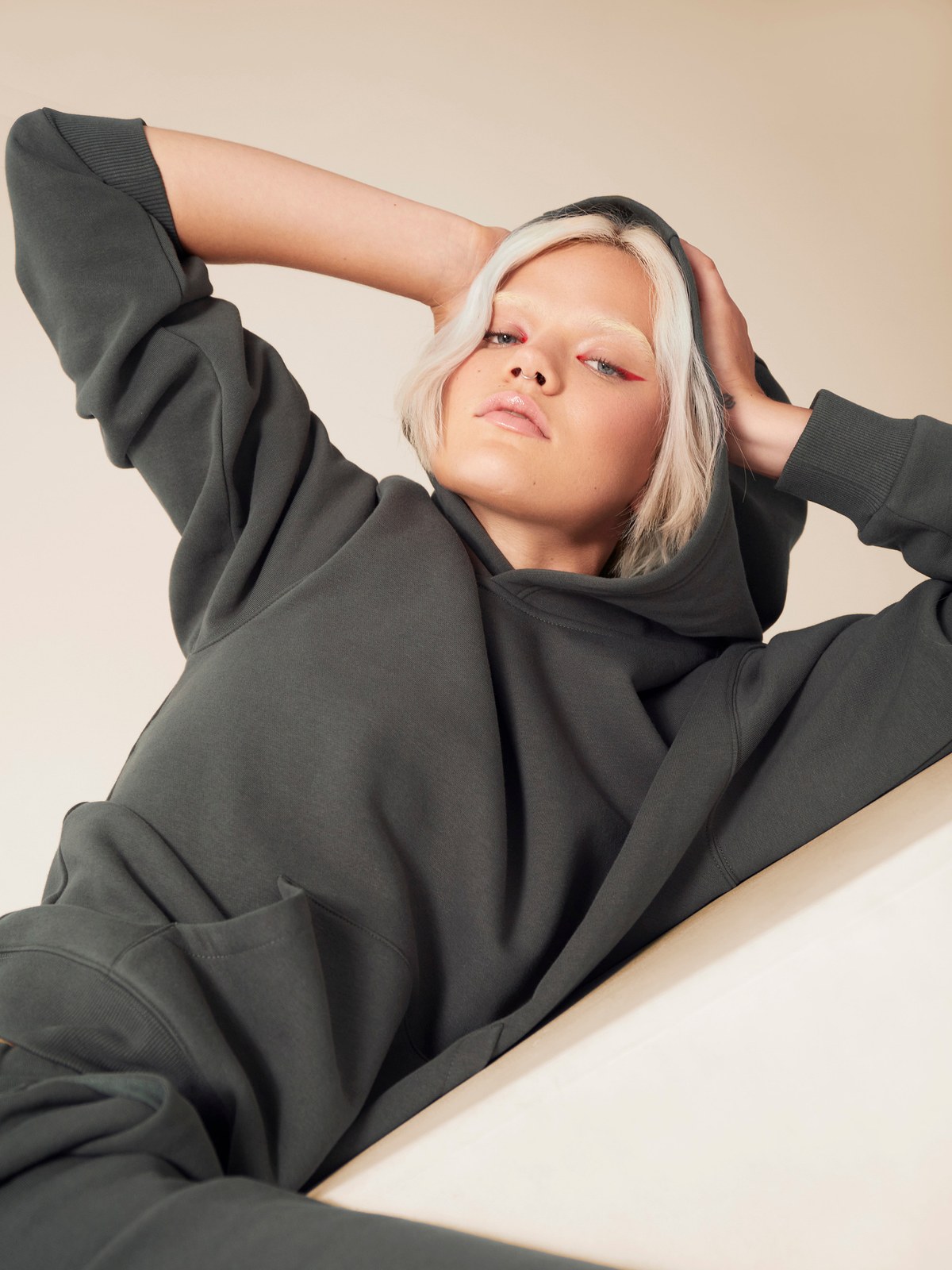 Woman reclining in a charcoal TKEES sweatshirt