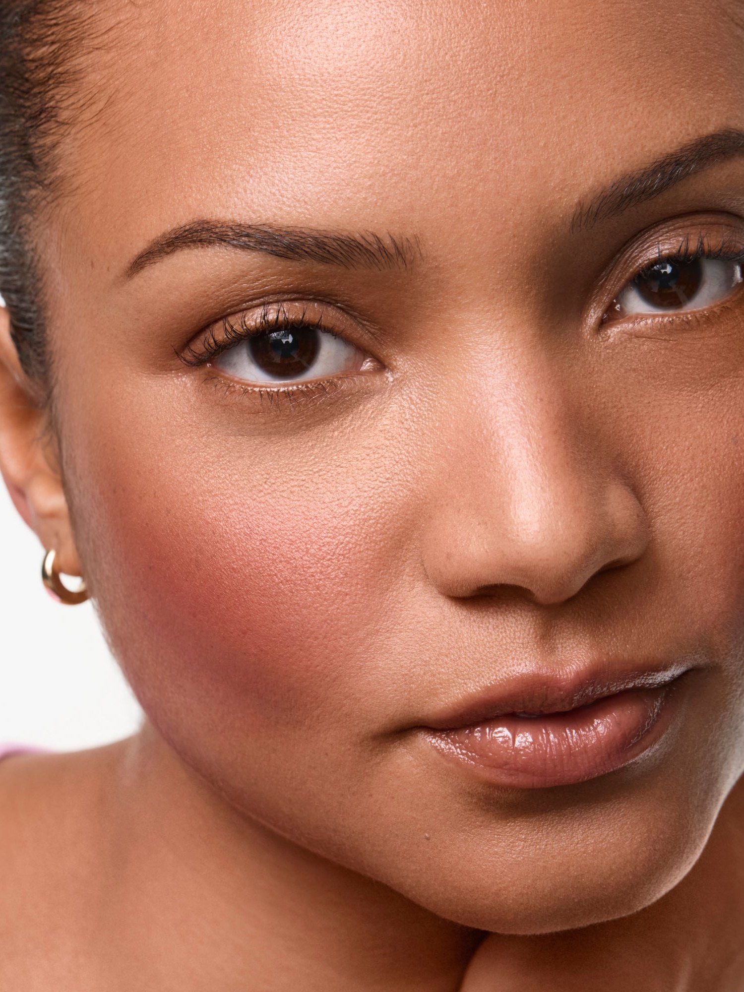 Close portrait of a woman with rosy blush and a pink top