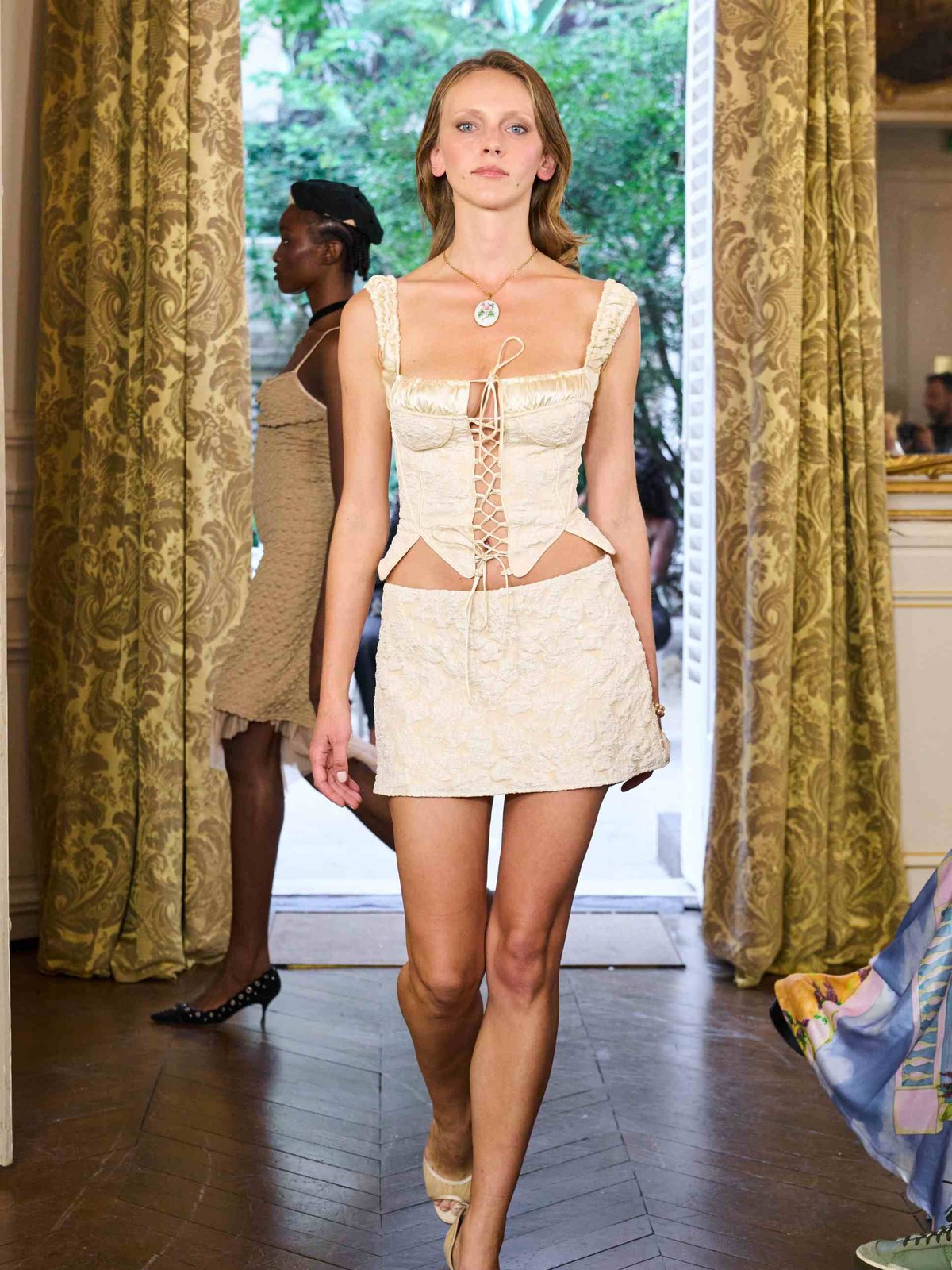 Runway model in an ivory Fait Par Foutch look with a lace-up bodice