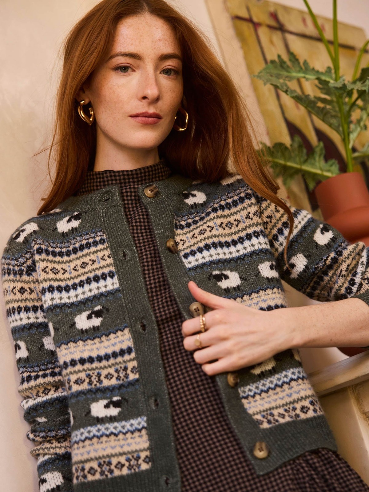 Model in a patterned Heartloom cardigan against a home interior