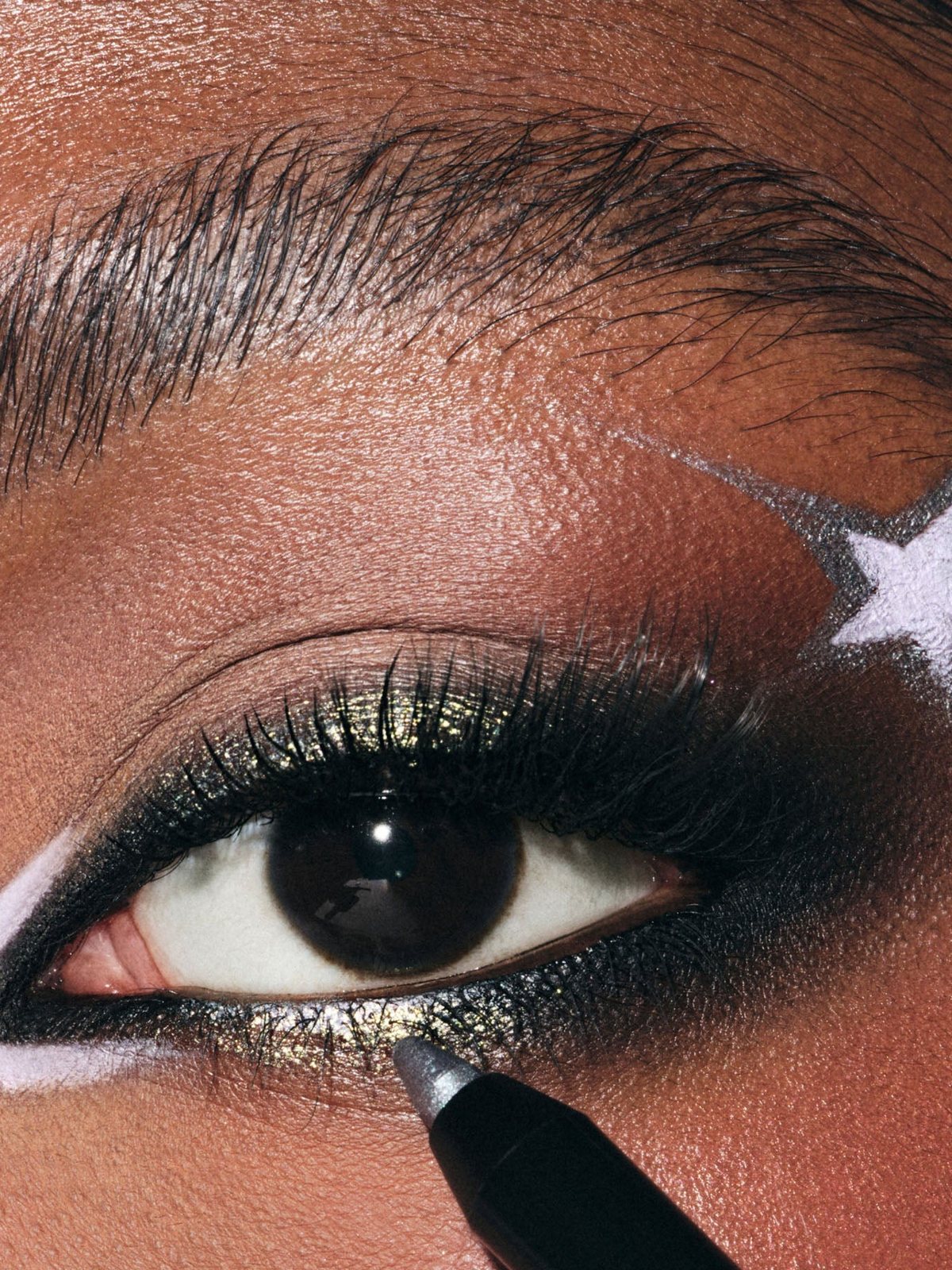 Macro of an eye with smoky green black liner and a white wing